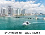 Scenic view of Miami city skyline with boat sailing in foreground sea, Florida, U.S.A.