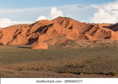 Scenic view of the Mongolian Flaming Cliffs tourist attraction in the Gobi Desert of Mongolia at sunset with the red rocks of the mountains appearing to glow