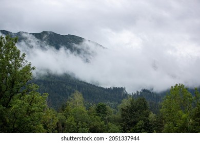A scenic view of a mountain enveloped in fog in St Johann im Pongau, Austria