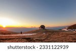 Scenic view of mountain hut Wolfsbergerhuette (Wolfsberger Huette) during sunrise on Saualpe, Lavanttal Alps, Carinthia, Austria, Europe. Snow covered meadow leading to remote alpine cottage