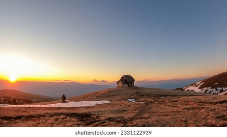 Scenic view of mountain hut Wolfsbergerhuette (Wolfsberger Huette) during sunrise on Saualpe, Lavanttal Alps, Carinthia, Austria, Europe. Snow covered meadow leading to remote alpine cottage - Powered by Shutterstock