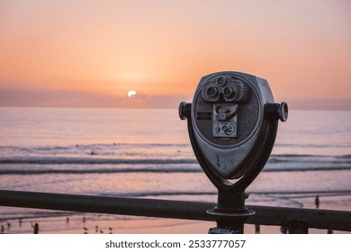 A scenic view of the ocean at sunset with a vintage coin-operated binocular viewer in the foreground. Perfect for concepts of exploration, nostalgia, or coastal travel. - Powered by Shutterstock