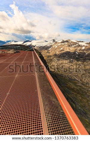 Scenic view on mountains landscape from Dalsnibba viewpoint, Geiranger Skywalk platform floor surface and glass guard rail, Norway.