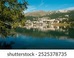 Scenic view on the St. Moritz mountain lake with the alpine resort on the other side on a bright summer day. Canton Grisons, Switzerland