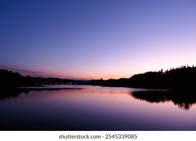 Scenic View Overlooking Logan Lake at Dusk from a Dock, with Stunning Pink, Purple, and Blue Hues Illuminating the Sky Just After Sunset - Logan Lake, Canada - Powered by Shutterstock