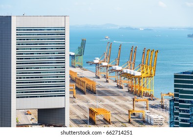 Scenic view of the Port of Singapore. Ship-to-shore (STS) gantry cranes at shipping yard on the sea background. Coastal urban industrial seascape.