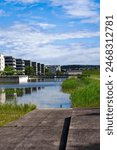 Scenic view of public park named Opfikerpark with apartment buildings and pond on a sunny spring day. Photo taken May 29th, 2024, Opfikon, Canton Zurich, Switzerland.