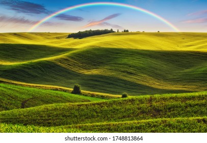 Scenic View Of Rainbow Over Green Field