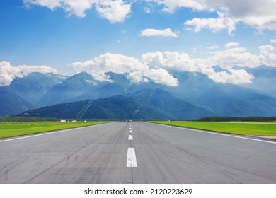 Scenic view of the runway road and mountain peaks in the clouds in the distance - Powered by Shutterstock