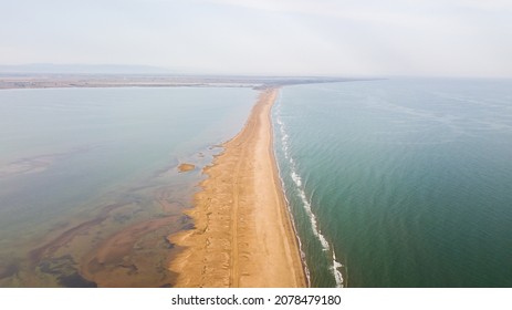 A scenic view of a sandy path between two oceans