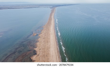 A scenic view of a sandy path between two oceans