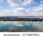 Scenic view of Sava river and settlements around Slavonski Brod during sunny day with fluffy clouds.