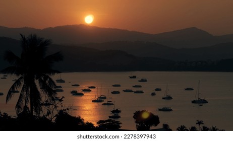 Scenic view sea yachts at parking during golden sunset in evening sky. Boat parking on background silhouettes hills and reflection sunset in sea water time lapse