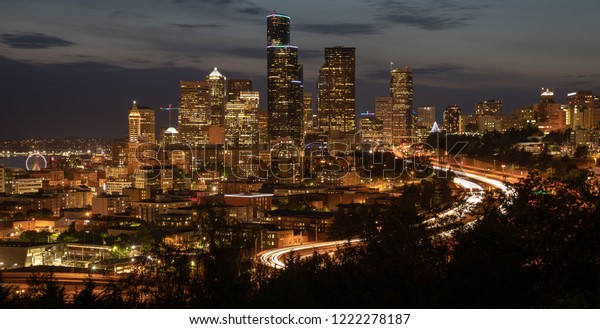 Scenic view of the Seattle skyline\
with car lights passing through during the night commute.\
