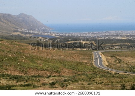 Scenic view of Sir Lowry's Pass, South Africa, showing the aftermath of a wildfire and winding road.