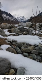 Scenic view of a snow capped mountain under snowy clouds