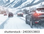 Scenic view snow covered city highway slippery mountain alpine road drive cars moving fast speed motion. Snowfall danger blizzard bad winter weather conditions. Cold snowy day snowstorm background