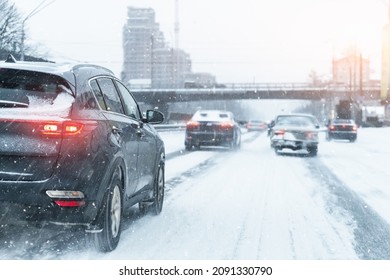 Scenic view snow covered city highway slippery road drive cars moving fast speed motion. Snowfall danger blizzard bad winter weather conditions. Urban cold snowy day snowstrom town background