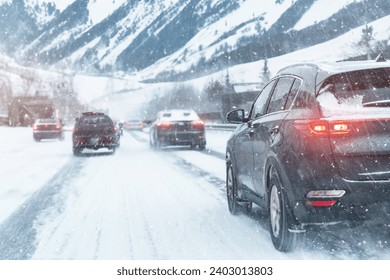 Scenic view snow covered city highway slippery mountain alpine road drive cars moving fast speed motion. Snowfall danger blizzard bad winter weather conditions. Cold snowy day snowstorm background
