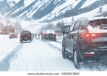 Scenic view snow covered city highway slippery mountain alpine road drive cars moving fast speed motion. Snowfall danger blizzard bad winter weather conditions. Cold snowy day snowstorm background