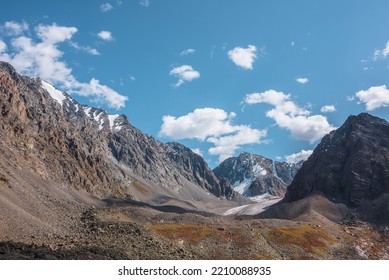 Scenic View To Sunlit Rocks And Large Snow Mountain Top With Glacier In Autumn Sunny Day. Vivid Autumn Colors In High Mountains. Motley Landscape With Sharp Rocks And Snow Mountain Peak In Bright Sun.