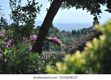 Scenic view through trees of a Spanish village with tiled rooftops and distant hills. - Powered by Shutterstock