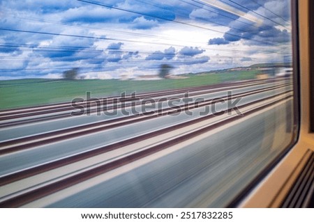 Scenic view through the window of a high-speed AVE train racing through Cordoba, Andalusia, Spain. Captures the dynamic movement and picturesque landscape.