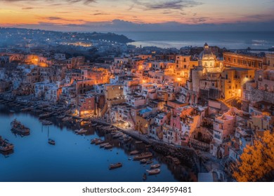Scenic view of the typical Corricella houses in Procida illuminated at sunset, Campania, Italy
