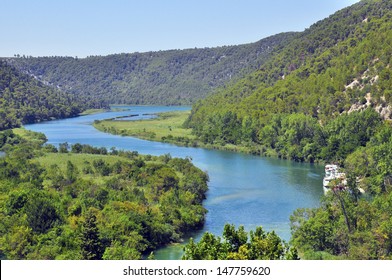 Scenic view of winding blue river between mountains, natural landscape in Krka park on summer, Croatia