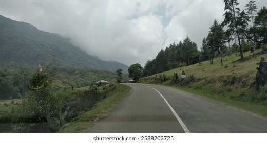 A scenic view of a winding road cutting through a mountain range.