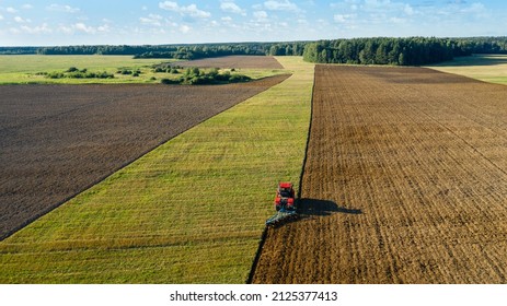 Scenic View Of Working Tractor In The Field Agricultural Field On A Summer Farm In The Evening. Aerial Photography, Top View Drone Shot. Agricultural Area Of Moscow Region. Agrarian Land In Summertime