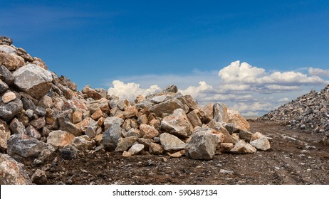 Scenic views, granite pile of different sizes, both large and small, on the ground, cloudy sky in the background.
