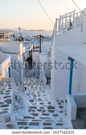 Scenic views of Mykonos, Greece featuring iconic whitewashed buildings, blue domes, windmills, cobbled streets, and vibrant coastal landscapes under bright Mediterranean sunlight.