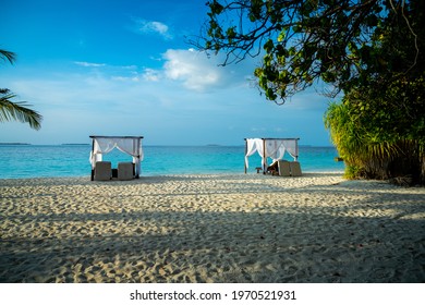 Scenic white sand beach with luxury tents and blue sky
