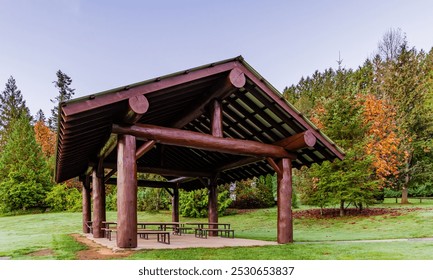 A scenic wooden picnic shelter in Mission, BC park surrounded by vibrant autumn foliage. Ideal for outdoor gatherings amidst a tranquil natural setting. - Powered by Shutterstock