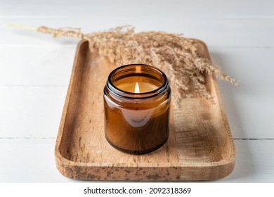 Scented Candle In A Glass Jar Mockup On A Marble Tray And Dry Grass Plant On White Wooden Background