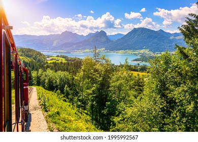 Schafbergbahn Mountain Train, Schafberg Mountain, Salzkammergut Region, Salzburg Land State, Austria. Journey To The Top Of Alps Through Lush Fields And Green Forests.View Of Lake Wolfgangsee.