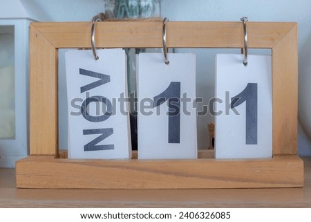 Schedule and organizer concept, Wooden calendar with white paper and flippable of 11 Nov (Eleven-November) on the table desk, Home decoration background.