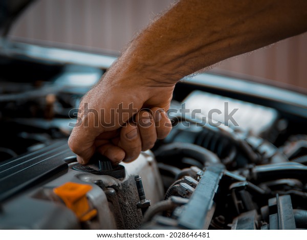 Scheduled\
maintenance of the car A car service specialist performs the\
procedure for changing the oil in the\
car