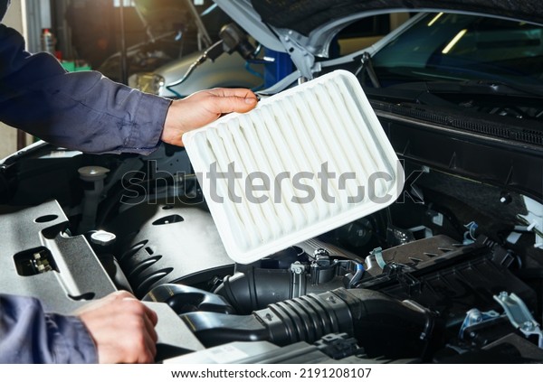 Scheduled vehicle maintenance, auto mechanic\
replacing air filter.