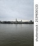 Schelde river views in the province of Antwerp on a cold winter day. Grey day in Antwerp. Riverside looking towards the city of Antwerp. River and city. 