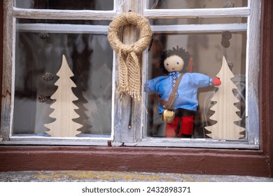 Schellenursli (a children's book character) displayed as a rag doll with the famous swiss cow bell in a window in Guarda, Engadine, Switzerland.