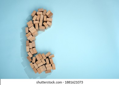 Schematic Telephone Receiver From Small Pieces Of Wood On A Blue Background Top View. Telephone Handset Design. Helpline. Phone Symbol Close-up