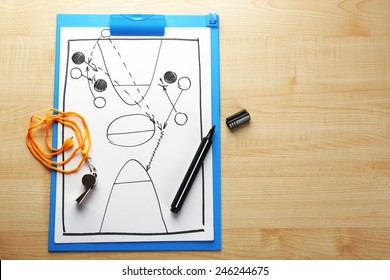 Scheme basketball game on clip board paper with marker and wooden table background