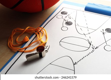Scheme basketball game on sheet of paper with basketball on wooden table background - Powered by Shutterstock