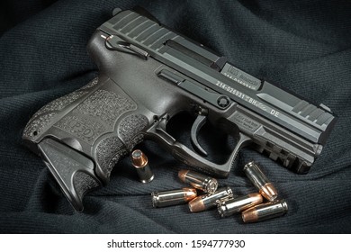 Schererville, Indiana/United States 8-8-2018. Heckler & Koch P30 SK 9mm semi-auto handgun with loose 9mm hollow point cartridges in foreground against a black fabric background