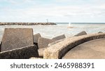 Scheveningen, The Hague, Netherlands - April 2024: Looking along the coastline towards Scheveningen Pier with the beach and promenade in the foreground on a sunny and partially cloudy day.