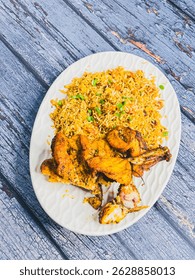 Schezwan Chicken Fried Rice in white platter at dark wooden background. Szechuan Rice is indo-chinese cuisine dish with bell peppers, green beans, carrot, chicken breasts.