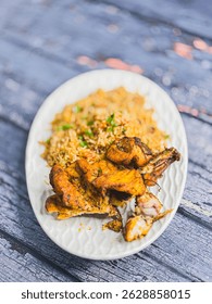 Schezwan Chicken Fried Rice in white platter at dark wooden background. Szechuan Rice is indo-chinese cuisine dish with bell peppers, green beans, carrot, chicken breasts.