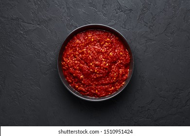 Schezwan Sauce In Black Bowl At Dark Background. Schezwan Sauce Is Indo-chinese Or Sichuan Cuisine Hot Sauce With Red Chilli, Garlic And Ginger.